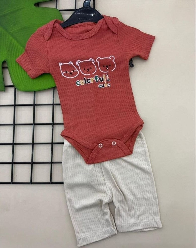 The Nile Luxuries coral ribbed knit baby bodysuit with bear print and white ribbed shorts. Short sleeves, snap closure.