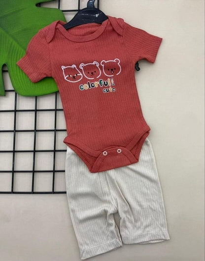 The Nile Luxuries coral ribbed knit baby bodysuit with bear print and white ribbed shorts. Short sleeves, snap closure.