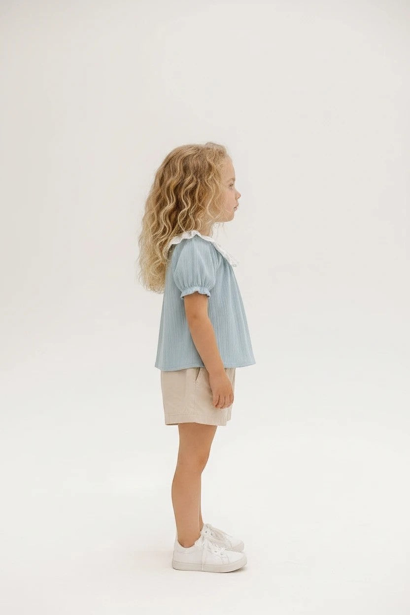 The Nile Luxuries girls blue textured puff sleeve top with white lace collar and ribbed knit fabric.