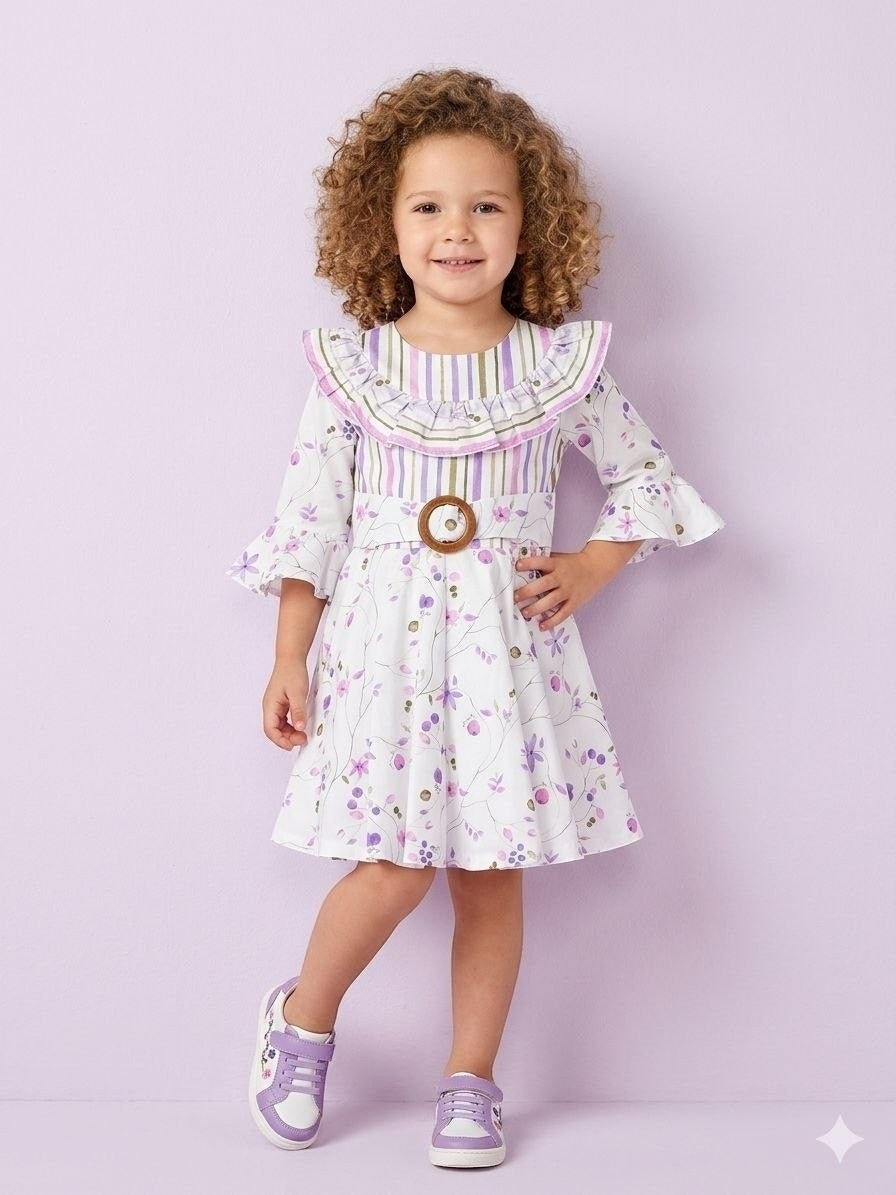 The Nile Luxuries Girls floral print dress with ruffle collar, bell sleeves, and wooden buckle belt. White with purple floral print.