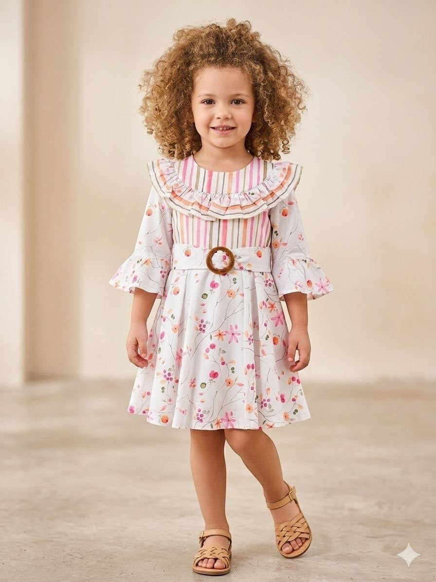 The Nile Luxuries Girls floral print dress with ruffle collar, bell sleeves, and wooden buckle belt. White with pink and orange flowers.