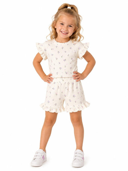 The Nile Luxuries girls' ivory ribbed knit floral print top with ruffled sleeves and matching shorts with ruffled hems.