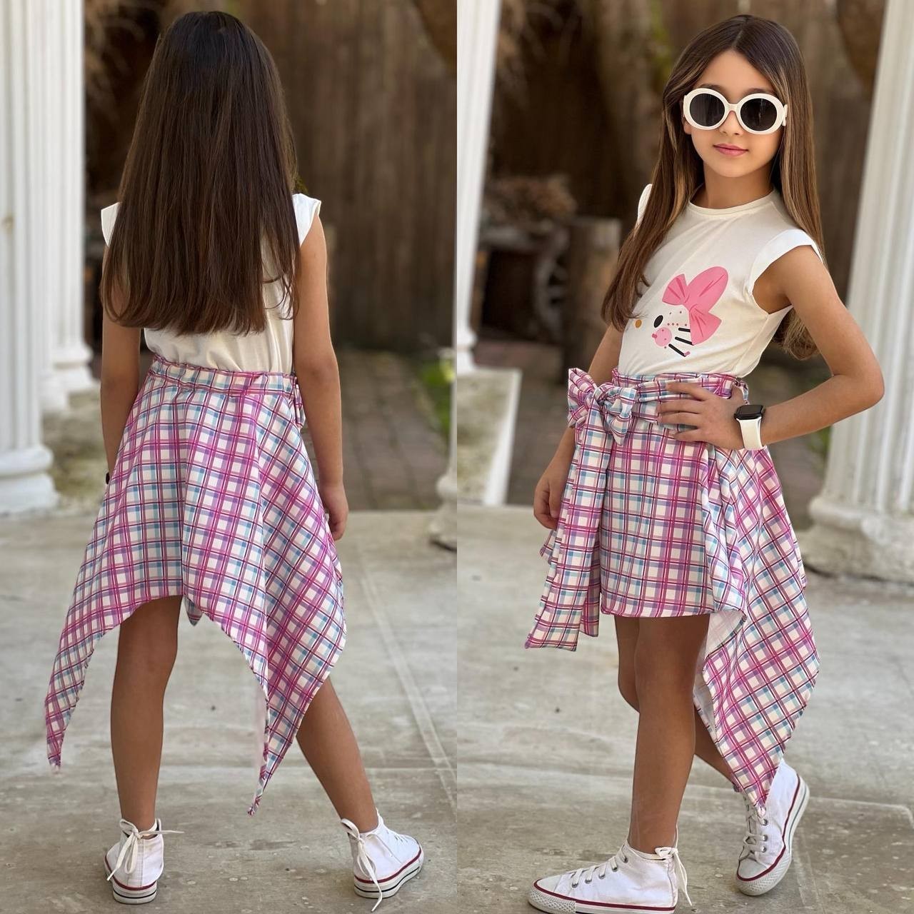 The Nile Luxuries girls white sleeveless top with pink bow graphic and pink plaid handkerchief hem skirt with tie waist.