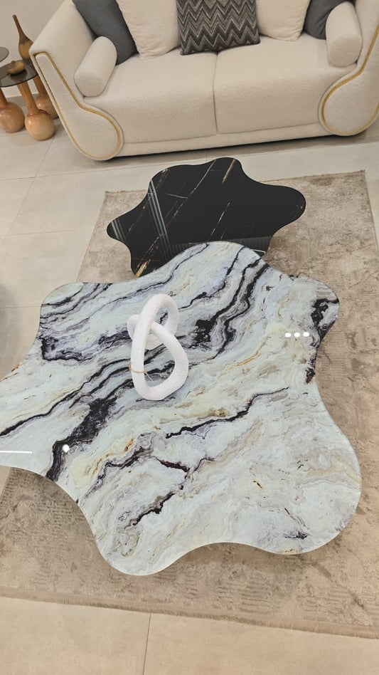 The Nile Luxuries modern coffee table set with organic marble-effect tops in white, black, and gold on black metal legs.