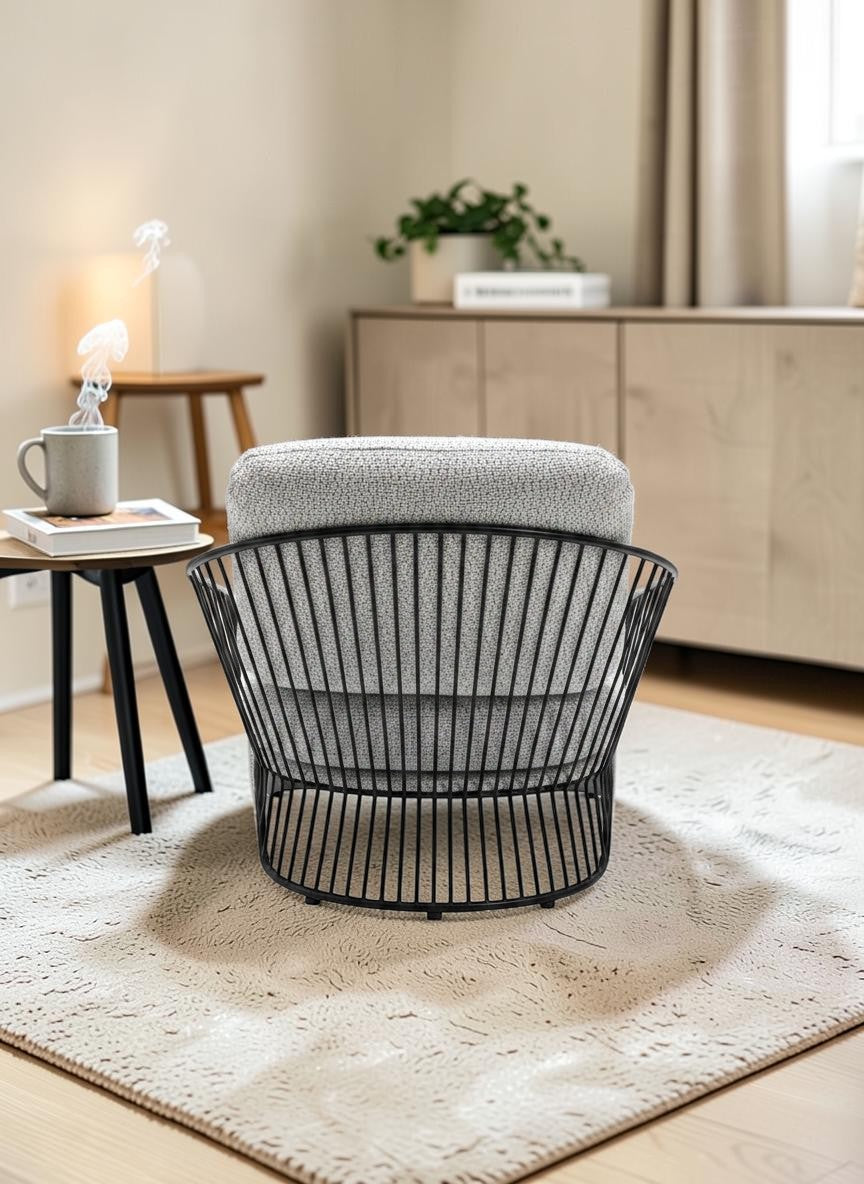 The Nile Luxuries modern armchair with light grey boucle upholstery and a black metal cage frame. Accent chair.
