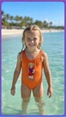 The Nile Luxuries orange one-piece swimsuit for girls with teddy bear graphic. Perfect for beach or pool.