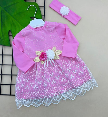 The Nile Luxuries baby girl's pink dress with white lace overlay, floral appliqué, and matching headband.