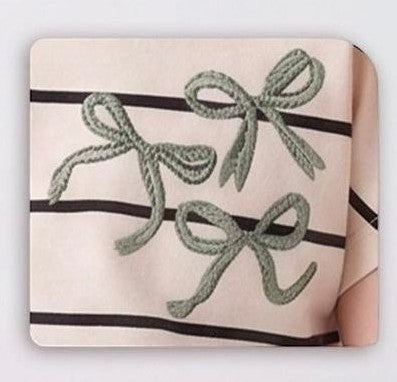 The Nile Luxuries pink and black striped t-shirt with embroidered sage green bows. Cotton blend.