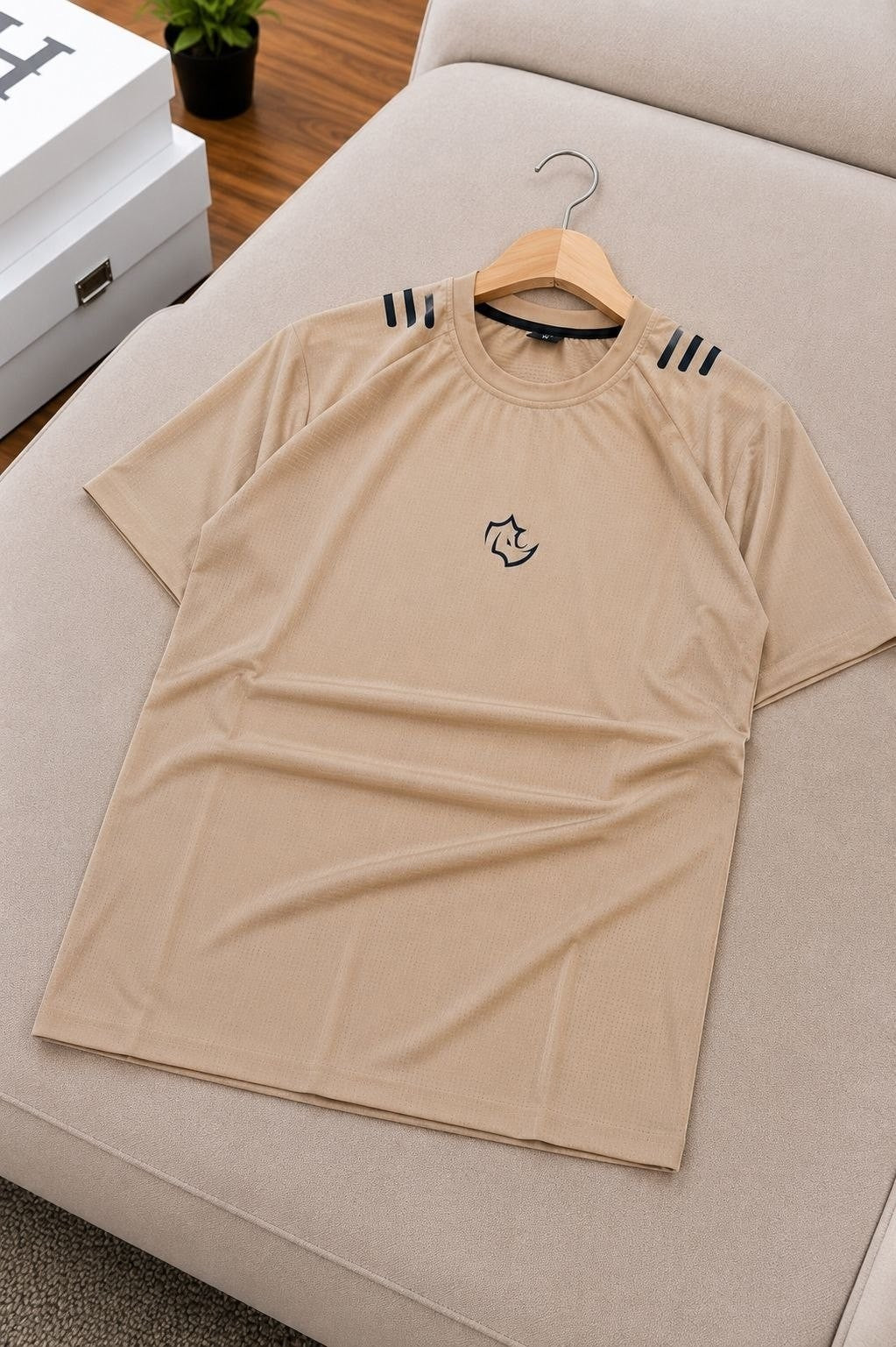 The Nile Luxuries tan short sleeve athletic t-shirt with crew neck and graphic logo on chest.