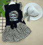 The Nile Luxuries toddler girl's black sleeveless top with dog graphic, leopard print skirt, and white hat. Cotton.