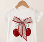 The Nile Luxuries white cotton t-shirt with cherry graphic, floral bow, and ruffled sleeves.