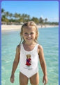 The Nile Luxuries white one-piece swimsuit for girls with a graphic teddy bear wearing a red dress and blue sash.