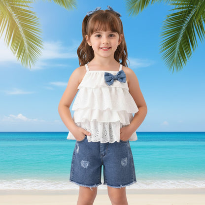 The Nile Luxuries white tiered eyelet ruffle tank top with denim bow paired with distressed denim shorts.