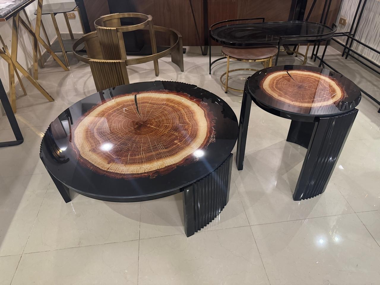 The Nile Luxuries Rustic Wood Slice Coffee Table Set with black pedestal bases and clear resin top showcasing wood grain.